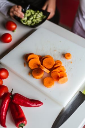 Anonymous kids preparing vegetables for salad