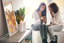 A woman showing a friend something on her phone