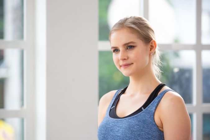 Blonde woman standing in bright room wearing work out clothes