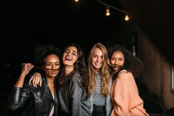 Multi-ethnic group of women celebrating at night