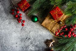 Christmas frame with branch and gifts on stone background
