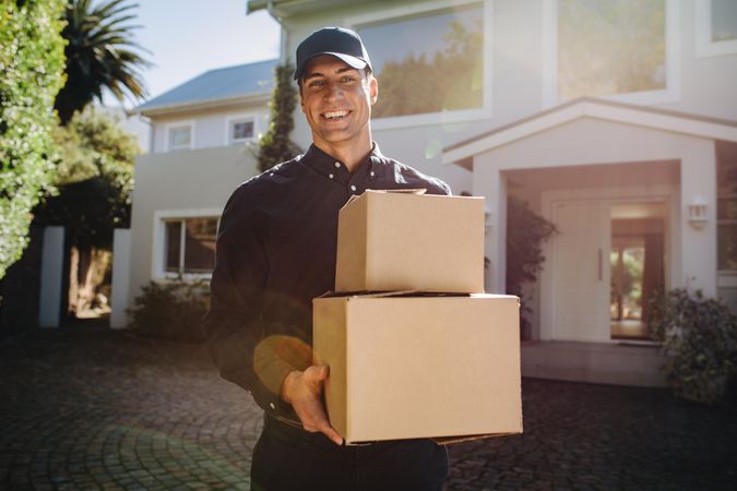 Smiling courier worker delivering parcel boxes