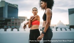 Two female athletes doing workout standing on rooftop 5arZG4