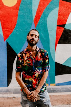 Cool bearded man in bright shirt against colorful wall
