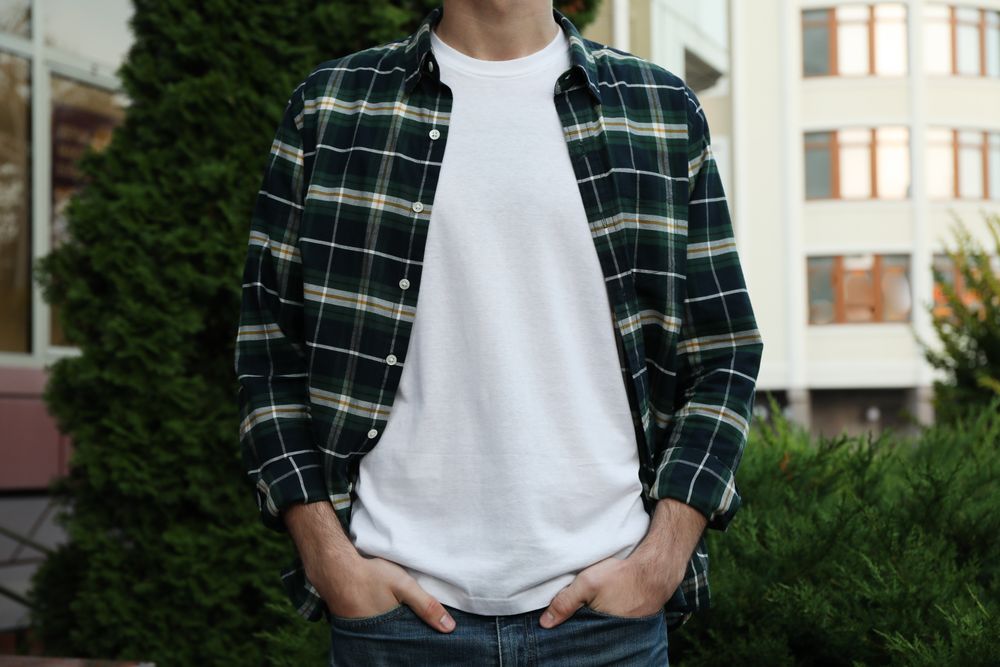 Men in blank t-shirt and green checkered shirt, space for text