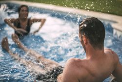 Woman splashing water on a man