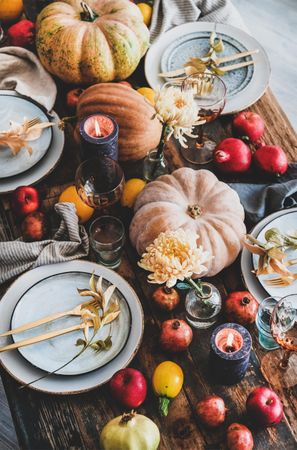 Fall table setting with squash, candles and pomegranates, top view