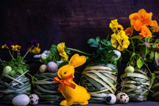 Easter holiday card with pots of bright flowers and decorative eggs and rabbit