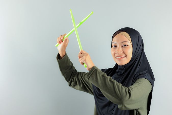 Asian Female Holding Green Rip Stick for Pound Fit, Sporty Concept