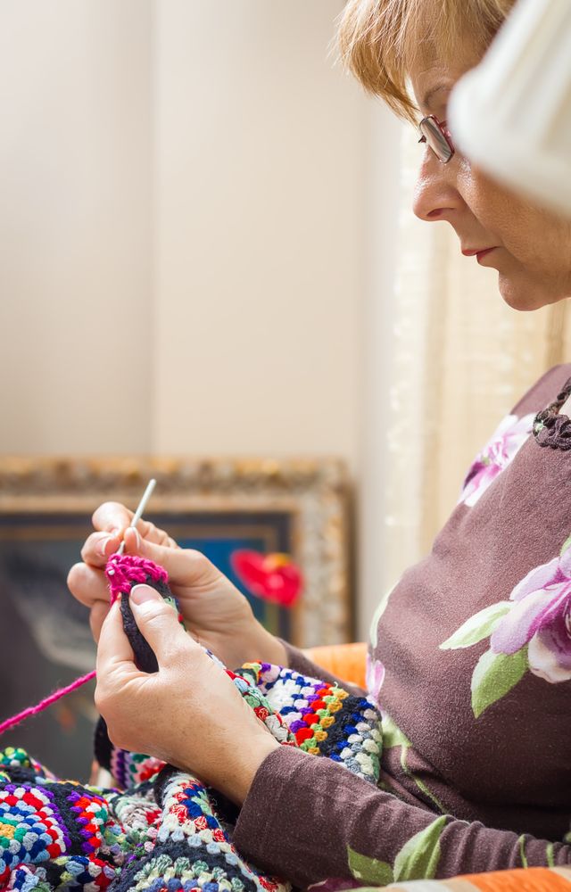 Portrait of woman knitting a vintage wool quilt