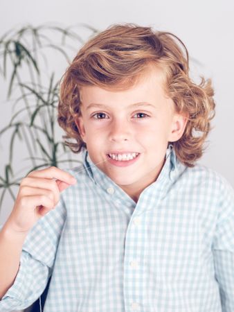 Cute preteen boy twitching tooth with thread