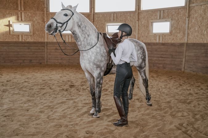 Rider with dapple gray horse in round arena