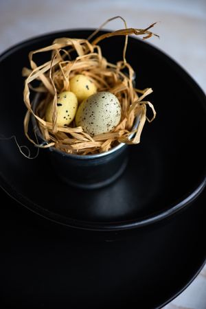 Small bowl of Easter eggs netled with hay