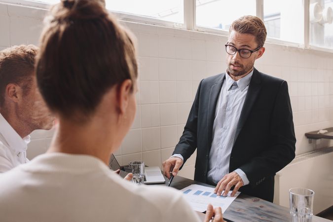 Young man explaining new business ideas to coworker during meeting