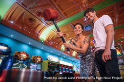 Happy couple at a gaming arcade having fun playing games 42Olqb