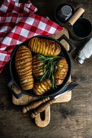 Potato fans in cast iron pan with rosemary