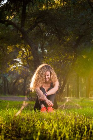 Happy woman sitting on sunny lawn