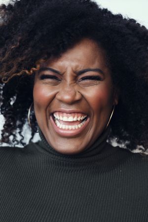 Portrait of a Black woman laughing with her eyes closed