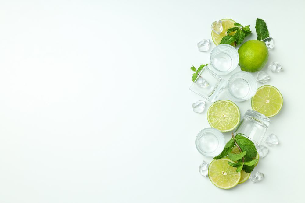 Glasses for shots and ingredients for cocktails on blank background