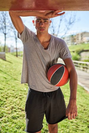 Sporty man with basketball in summer park