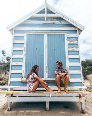 Man and woman sitting front of shed during daytime