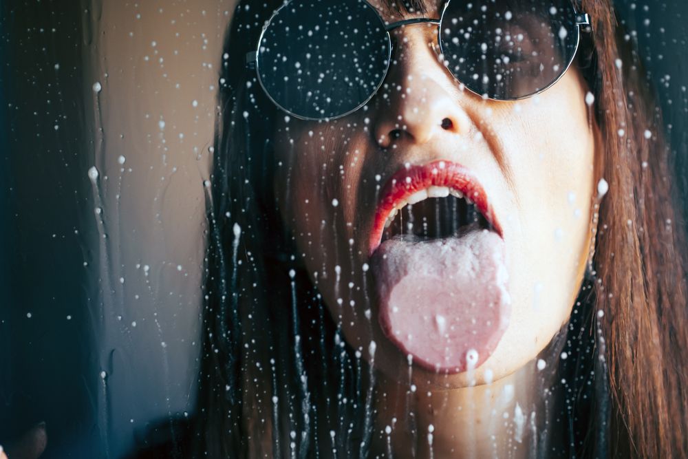 woman licking wet glass