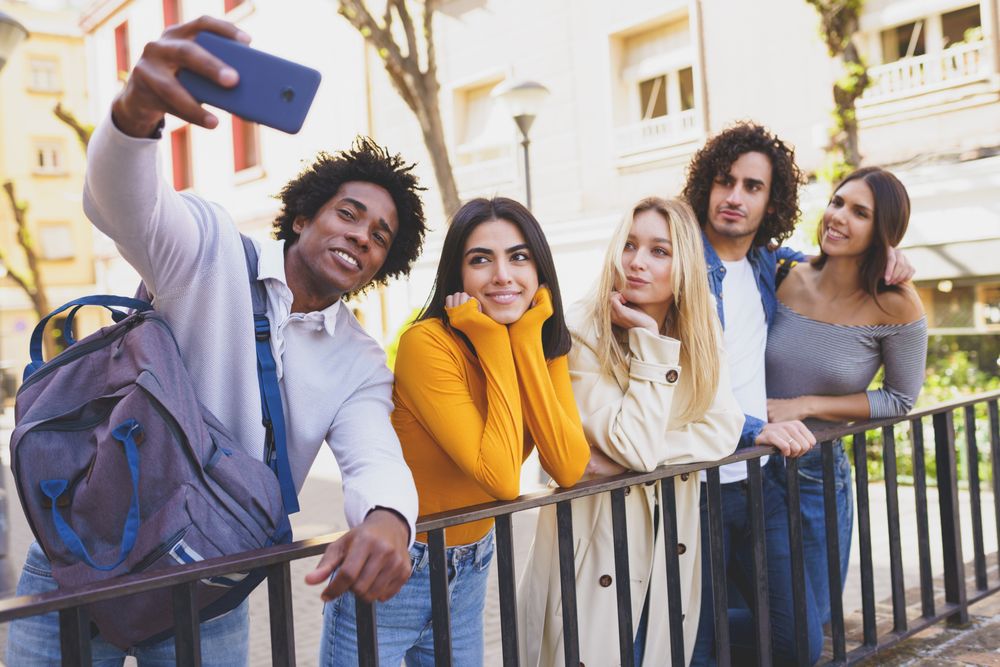 Friends taking selfies together outside