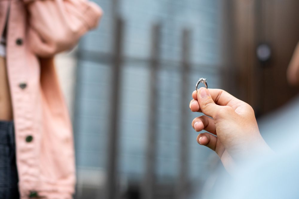 Man on knee with engagement ring asking girlfriend to propose.