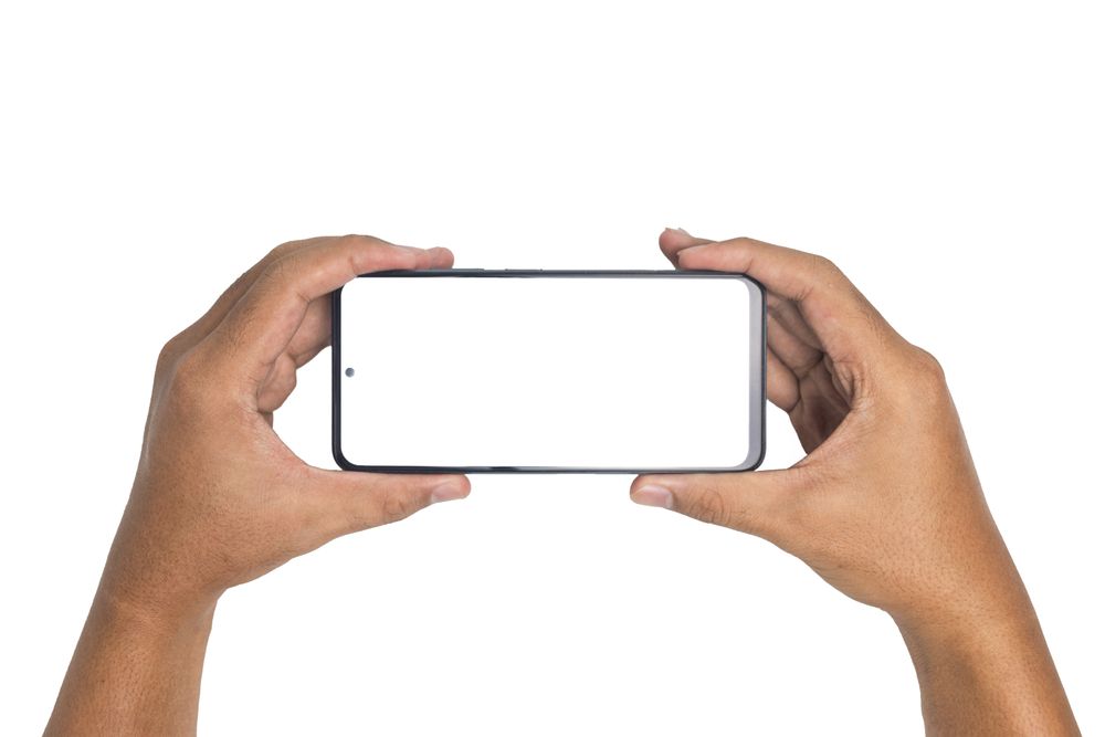 male hand holding smartphone horizontally with blank screen smartphone