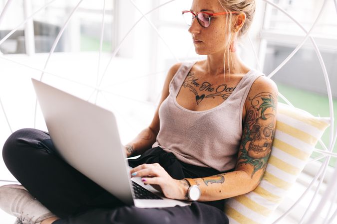 Tattooed woman working on a laptop
