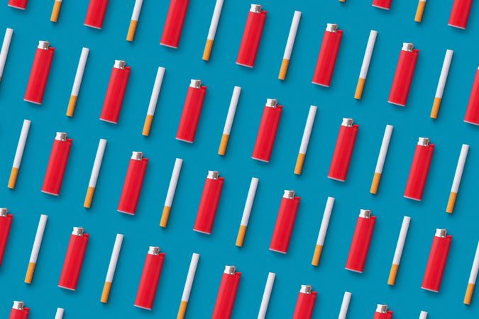 Red lighters and cigarettes on blue background