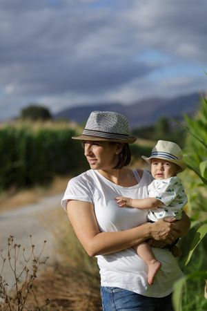 Adorable mother and child on hand enjoying and laughing in field