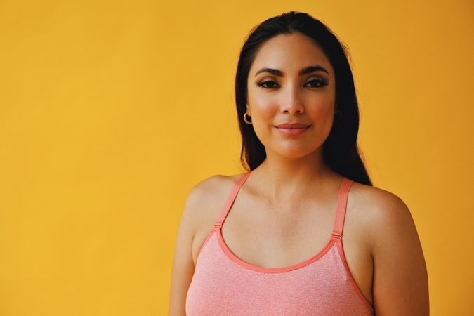 Hispanic woman in yoga clothes looking at camera, close up with copy space