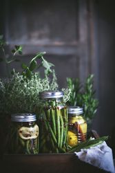 Fresh green vegetables with fruits and glass jars