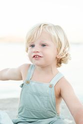 Charming blond toddler on summer beach