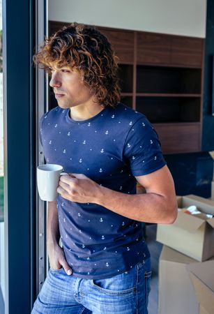 Man resting from unpacking moving boxes