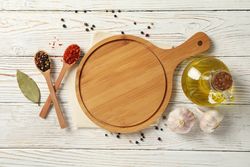 Composition with cutting board and spices on wooden background
