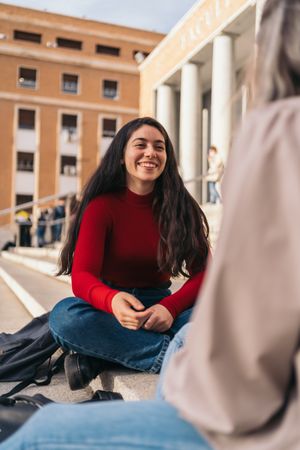 Two students sitting on the stairs of the college
