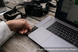 Photographer inserting memory card into laptop bxaQj0