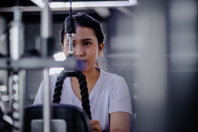 Focused woman exercising on a cable machine for upper body stren