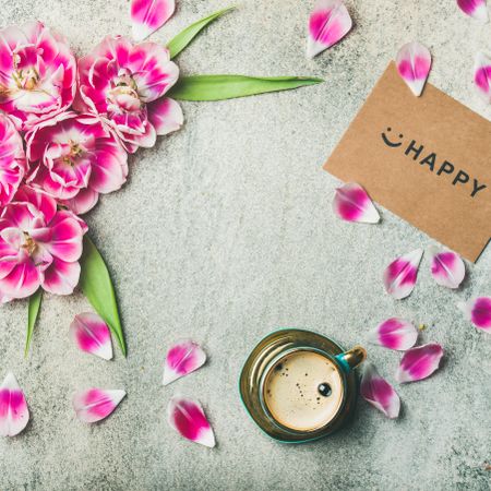 Spring flowers, coffee, and paper with text over grey background