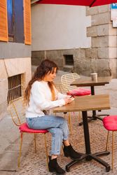 Young woman using smartphone in outdoors cafe