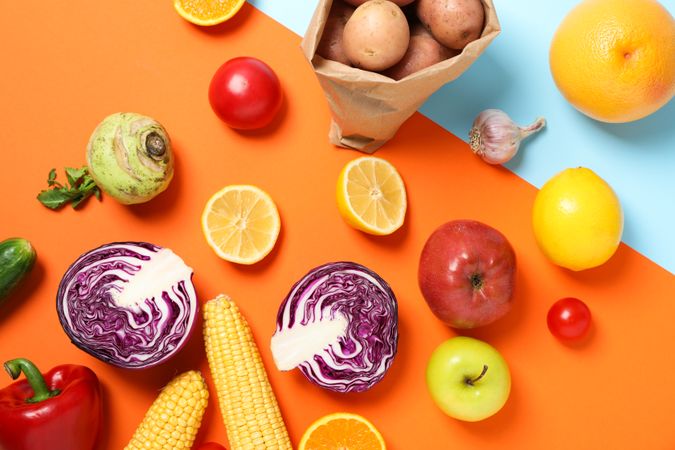 Different vegetables and fruits on two tone background, space for text