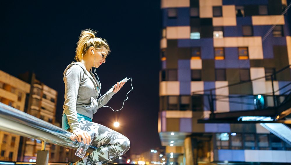 Focused blonde woman looking at video on smartphone app