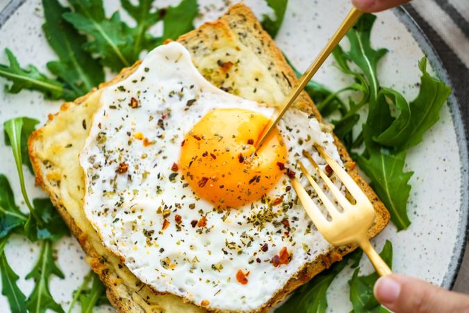 Delicious breakfast of fried eggs with toast and salad.