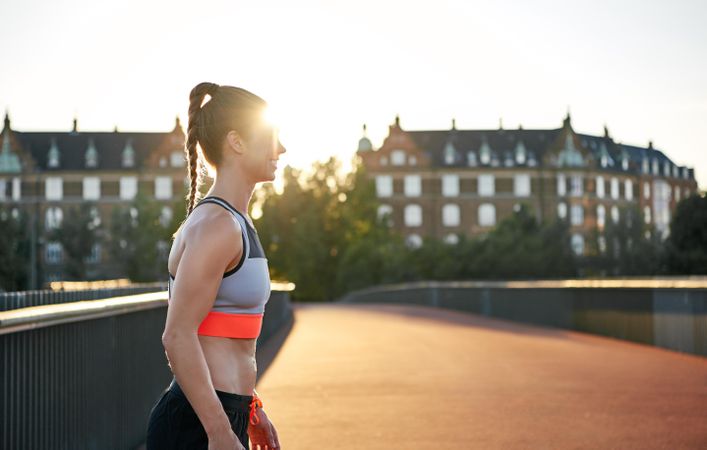 Side view of athletic woman on European bridge