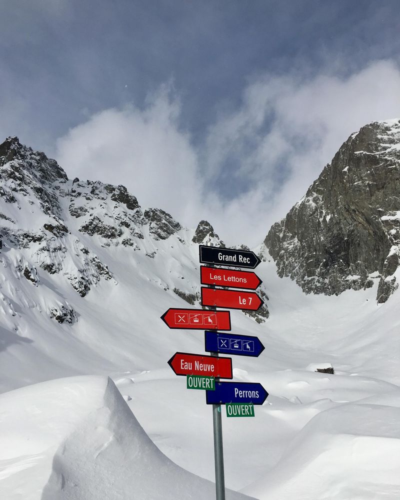 Red and blue road sign on in snow covered mountain in La Conversion, Vaud, Switzerland