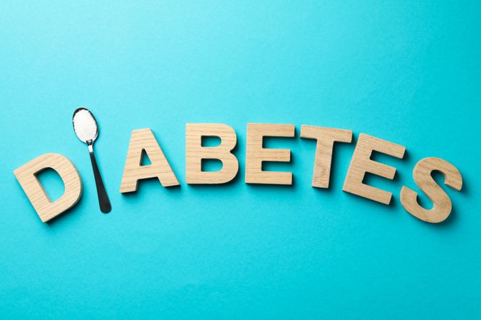 Word Diabetes made of wooden letters on turquoise background