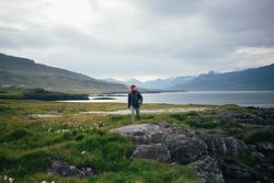 Man hiking on grass near lake