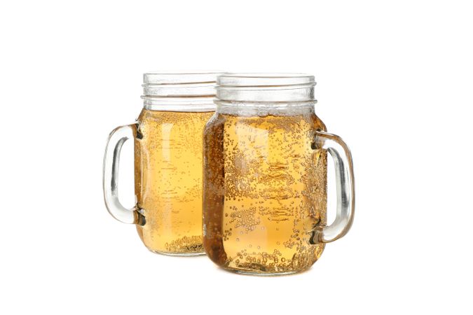 Glass jars with cider isolated on blank background